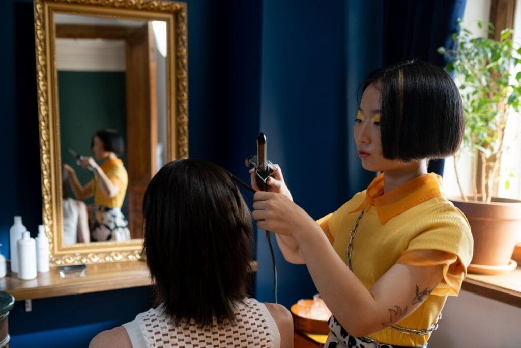 A woman using curling Iron for setting the hair