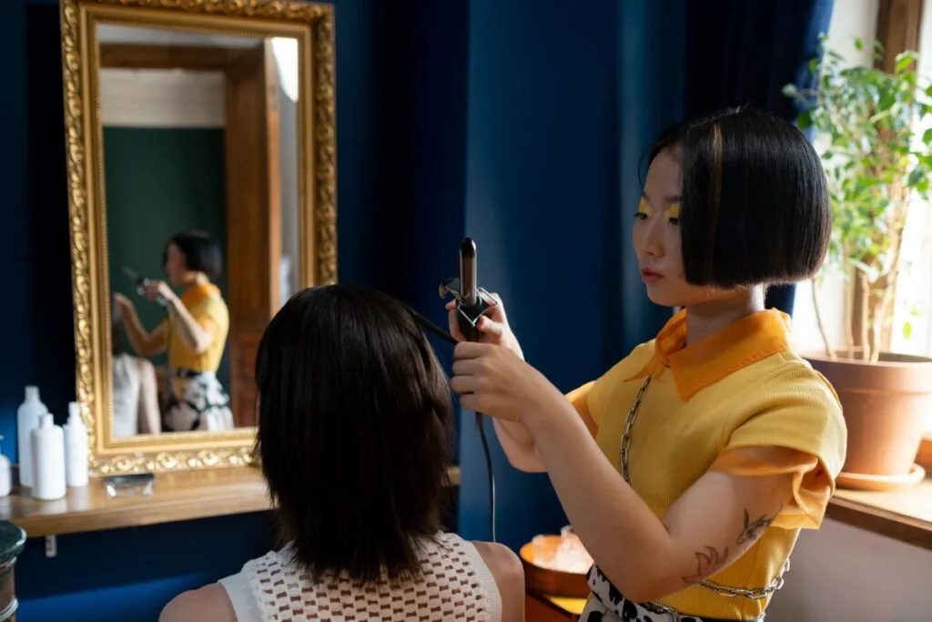 A woman using curling Iron for setting the hair